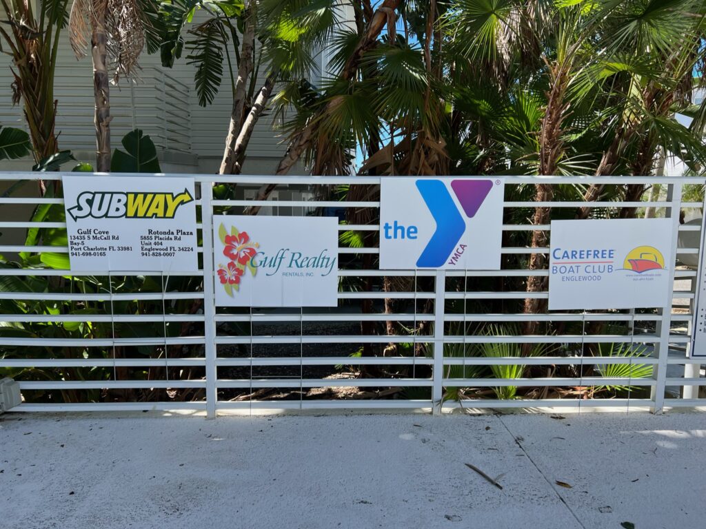 sponsor logos hanging of a fence